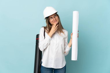 Slovak mimar kız elinde mavi arka planda izole edilmiş planlar tutarken gülümsüyor.
