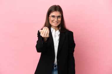 Pembe arka planda izole edilmiş genç beyaz bir kadın davet ediyor. Gelmene sevindim.