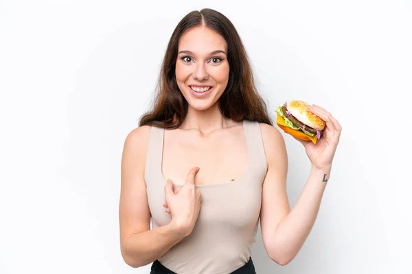 Młoda Kaukaska Kobieta Trzyma Hamburgera Izolowane Białym Tle Zaskoczeniem Wyraz — Zdjęcie stockowe
