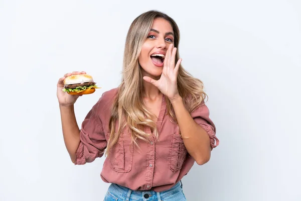 Młoda Ładna Urugwajska Kobieta Trzyma Hamburgera Odizolowany Białym Tle Krzycząc — Zdjęcie stockowe