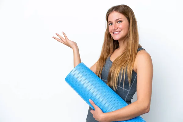年轻的女运动员一边去上瑜伽课 一边拿着垫子向旁边伸出手来 感谢她邀请她来 — 图库照片