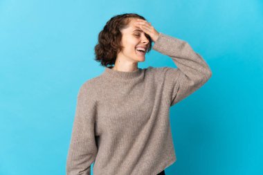 Young English woman isolated on blue background smiling a lot