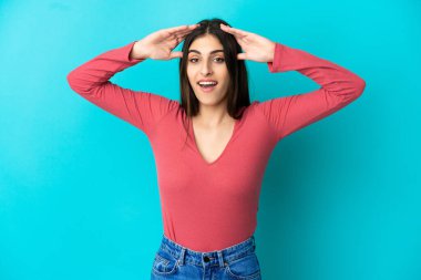 Mavi arka planda, sürpriz bir ifadeyle izole edilmiş beyaz bir kadın.