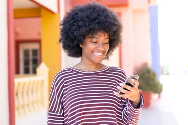 Chica Afroamericana Usando Teléfono Móvil Aire Libre Con Expresión Feliz — Foto de Stock