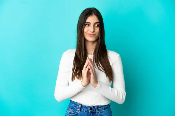 stock image Young caucasian woman isolated on blue background scheming something