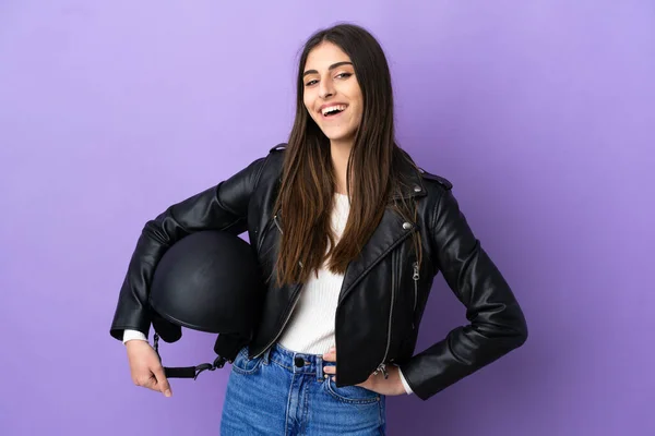若いですCaucasian女性とともにオートバイヘルメット隔離上の紫色の背景Posingとともに腕でヒップと笑顔 — ストック写真