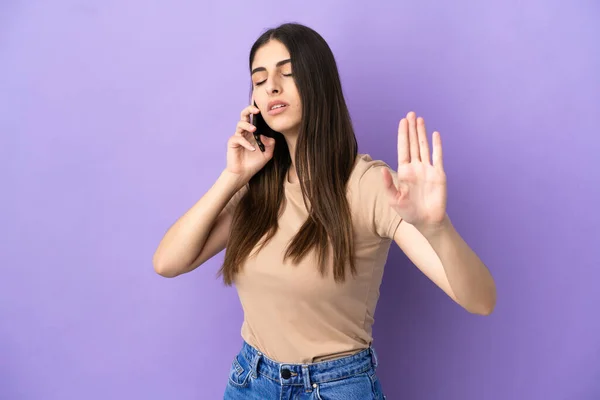 Νεαρή Καυκάσια Γυναίκα Που Χρησιμοποιεί Κινητό Τηλέφωνο Απομονώνονται Μωβ Φόντο — Φωτογραφία Αρχείου