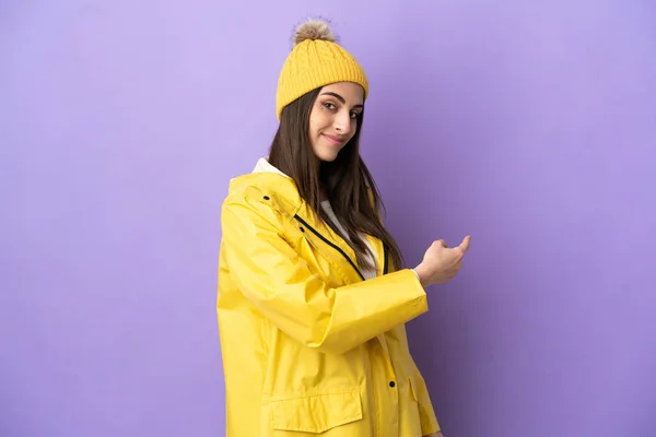 Νεαρή Καυκάσια Γυναίκα Που Φοράει Αδιάβροχο Παλτό Απομονωμένο Μωβ Φόντο — Φωτογραφία Αρχείου