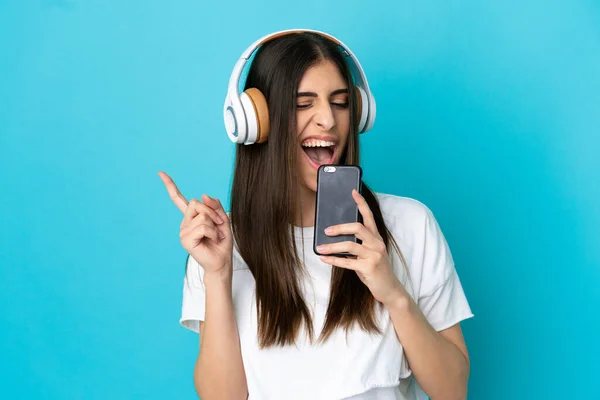 핸드폰으로 음악을 노래를 부르는 배경의 인디오 — 스톡 사진