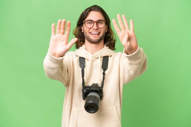 İzole edilmiş arka planda genç fotoğrafçı parmaklarıyla dokuz kişi sayıyor.