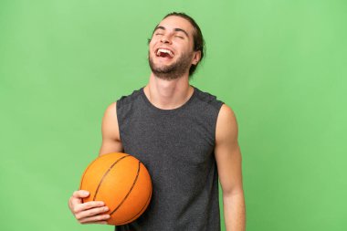 Genç basketbolcu arka planda gülüyor.