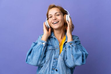 Mor arka planda müzik dinleyen genç Gürcü kadın.