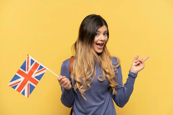 Молодая Россиянка Флагом Великобритании Желтом Фоне Указывая Пальцем Сторону Представляя — стоковое фото