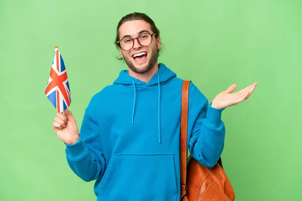 Mladý Pohledný Muž Drží Britskou Vlajku Nad Izolovaným Pozadím Šokovaným — Stock fotografie