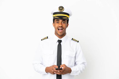 İzole edilmiş beyaz arka plan üzerinde Afrikalı Amerikan Uçak Pilotu şaşırdı ve bir mesaj gönderiyor