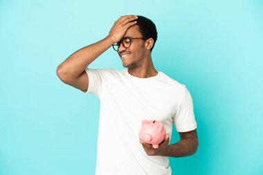 Mavi arka planda kumbara tutan Afro-Amerikalı yakışıklı bir adam bir şey fark etti ve çözüme niyetlendi.