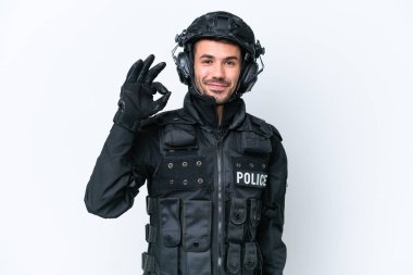 Beyaz arka planda izole edilmiş beyaz SWAT elemanı parmaklarıyla tamam işareti gösteriyor.