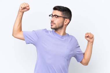 Beyaz arka planda izole genç beyaz adam güçlü jest yapıyor.