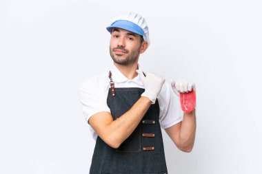 Kasap beyaz önlük giymiş ve soyutlanmış beyaz arka planda taze et servis ediyor gururlu ve kendini beğenmiş.