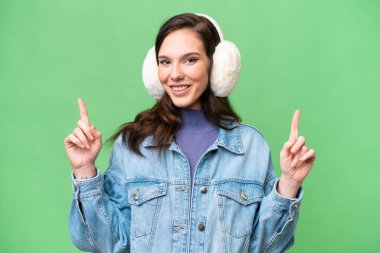 Kafkasyalı genç bir kadın, izole edilmiş arka planda kışlık kuklalar takıyor. Harika bir fikir.