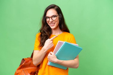 Tecrit edilmiş geçmişi olan beyaz bir kadın öğrenci bir ürünü sunmak için kenarı işaret ediyor.
