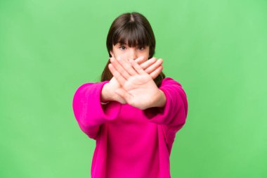 İzole edilmiş arka planda küçük beyaz bir kız bir hareketi durdurmak için el hareketi yapıyor.