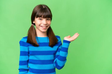 İzole edilmiş arka plan üzerinde küçük beyaz bir kız bir ilan vermek için avucunun içinde hayali bir mekan tutuyor.