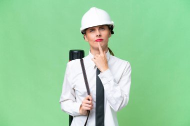 Miğferli genç bir mimar kadın, izole edilmiş bir geçmişin planlarını tutuyor.