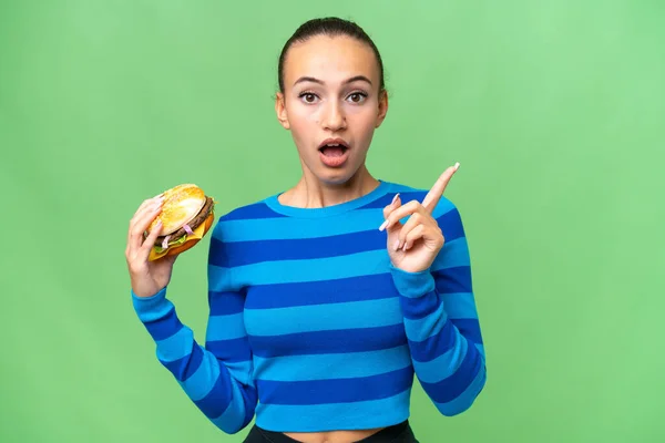 Young Arab Woman Holding Burger Isolated Background Intending Realizes Solution — Stock Photo, Image