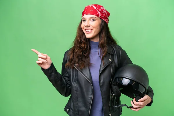 若いですCaucasian女性とともにオートバイヘルメット上の隔離された背景指差し指へザ側 — ストック写真
