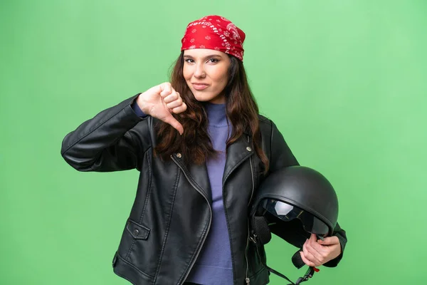 若いですCaucasian女性とともにオートバイヘルメット上の隔離された背景ショー親指ダウンとともに負の式 — ストック写真
