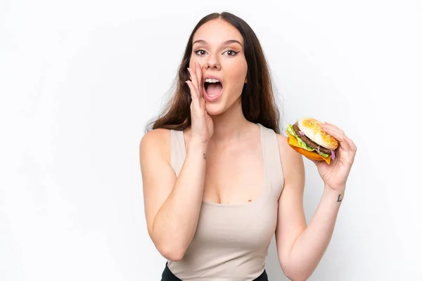 Junge Kaukasische Frau Hält Einen Burger Isoliert Auf Weißem Hintergrund — Stockfoto