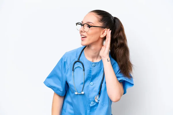 Νεαρή Καυκάσια Χειρουργός Γιατρός Γυναίκα Απομονωμένη Λευκό Φόντο Ακούγοντας Κάτι — Φωτογραφία Αρχείου