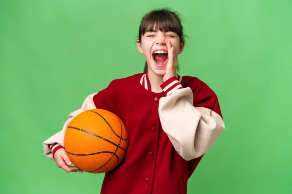 小さいですCaucasian女の子プレイバスケットボール上の隔離された背景叫びとともに口全体オープン — ストック写真