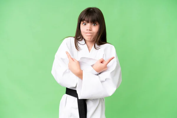 Little Caucasian Girl Doing Karate Isolated Background Pointing Laterals Having — Stock Photo, Image