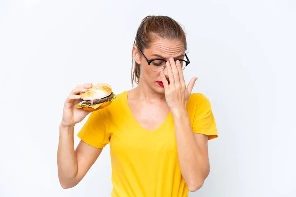 Młoda Kaukaska Kobieta Trzyma Hamburgera Białym Tle Zmęczonym Chorym Wyrazem — Zdjęcie stockowe