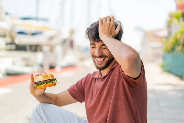 Młody Arabski Przystojny Mężczyzna Trzymając Hamburgera Świeżym Powietrzu Zrozumiał Coś — Zdjęcie stockowe