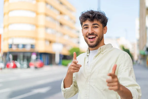 Mladý Arabský Pohledný Muž Venku Ukazuje Dopředu Usmívá — Stock fotografie