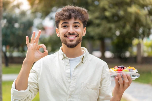 Jonge Arabische Knappe Man Houdt Een Kom Fruit Buitenlucht Tonen — Stockfoto