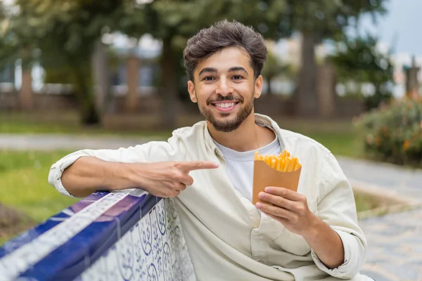 Jonge Arabische Knappe Man Houdt Gebakken Chips Buiten Wijst Het — Stockfoto