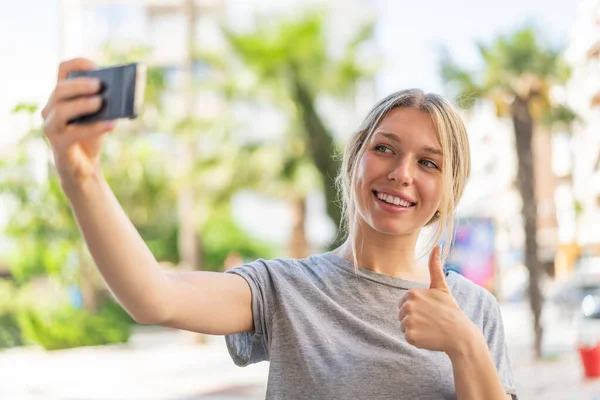 Açık Havada Genç Sarışın Bir Kadın Cep Telefonuyla Selfie Çekiyor — Stok fotoğraf