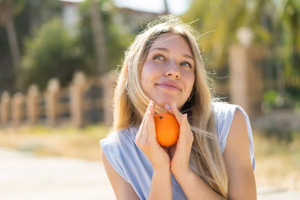 Açık Havada Elinde Portakal Tutan Genç Sarışın Kadın — Stok fotoğraf
