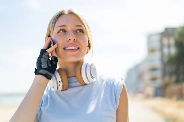 Молодая Блондинка Улице Спортивной Одежде Поддерживает Разговор Мобильным Телефоном — стоковое фото