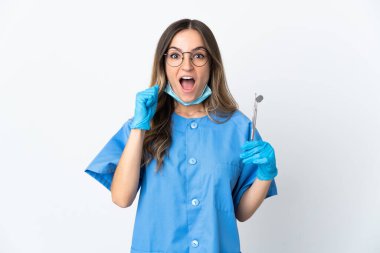 Pembe arka planda izole edilmiş araçları elinde tutan Romen kadın diş hekimi zaferi kutluyor