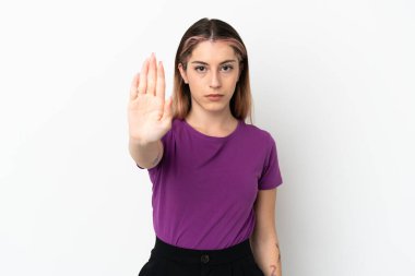 Beyaz arka planda izole edilmiş genç beyaz kadın dur hareketi yapıyor.