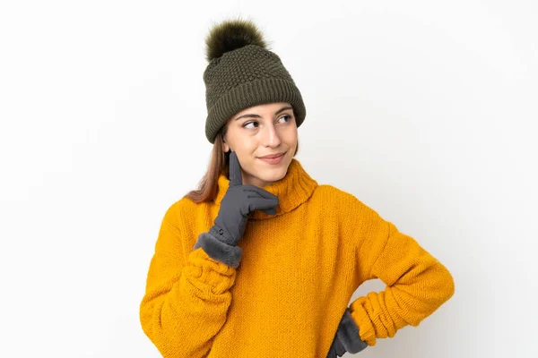 年轻姑娘戴着冬帽 背景是白的 抬头一看就想出了个主意 — 图库照片