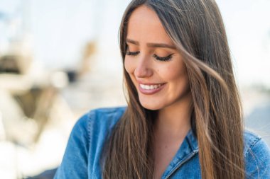 Açık havada genç bir kadın Neşeli bir ifadeyle