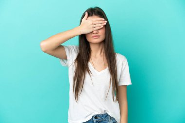 Mavi arka planda, gözleri elle kaplanmış beyaz bir kadın. Bir şey görmek istemiyorum.