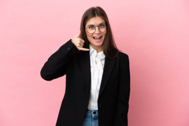 Pembe arka planda izole edilmiş genç beyaz kadın telefon jesti yapıyor. Bana geri dönüş işareti ver.