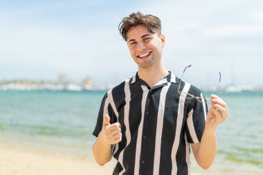 Neşeli gözlüklü genç yakışıklı adam.